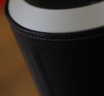 Smukła kolumna ze skóry i szkła emitująca dźwięk we wszystkich kierunkach