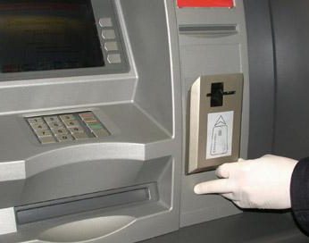 Mocowany na szczelinie bankomatu miniskaner odczytuje kod magnetyczny karty, zanim trafi ona do systemu.