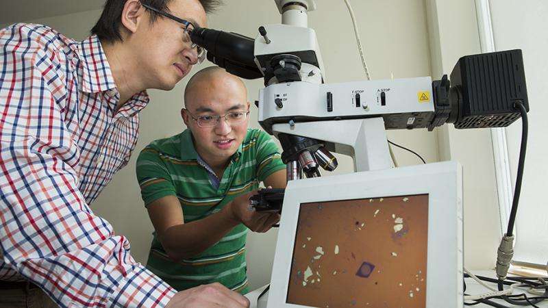 Dr Larry Lu (po lewej) i Jiong Yang wraz z soczewką wyświetloną na ekranie monitora (fioletowe kółko). Fot. Stuart Hay, ANU