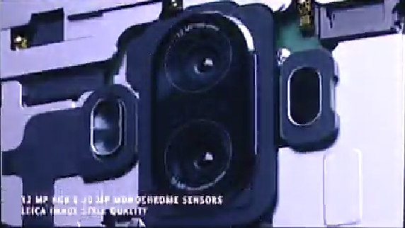 Klatka filmu prezentująca częściowo 'rozebrany' model Huawei Mate 9. System laserowego wspomagania ustawiania ostrości widać po prawej stronie obiektywów.